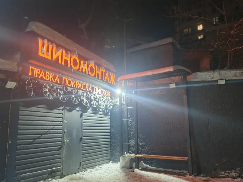 Освещённая вывеска шиномонтажа зимним вечером